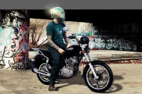 Piloto com a Chopper Road embaixo de um viaduto com as paredes grafitadas ao fundo 8