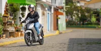 Mulher Pilotando A Moto Honda Biz 125 Prata Fosco Em Rua De Paralelepipedo 28