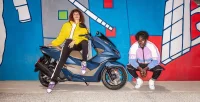 Homem E Mulher Ao Lado Da Moto Honda PCX Azul Estacionada Em Fundo Com Mural Colorido 22