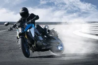 foto em action da nova GSX-S1000 com o piloto na pista e uma fumaça saindo do pneu traseiro 0