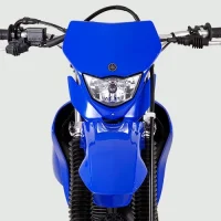 Moto de moto off-road TT-R 230 azul e preta de frente mostrando em detalhe o farol 32